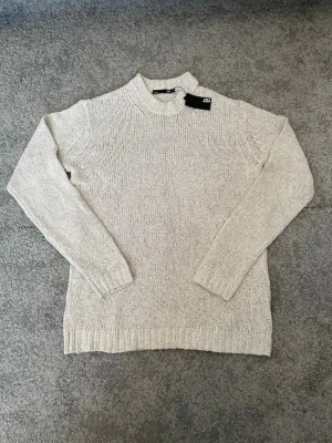 Beige stickad tröja  - En enkel och stilren beige stickad tröja från Lager 157. Tröjan har rund halsringning, långa ärmar och ribbade muddar vid ärmslut och nederkant. Perfekt basplagg för lager på lager och passar till det mesta. Helt oanvänd och orörd och finns inte tillgänglig att köpa på lager 157 längre. Perfekt skick och luktar fortfarande nyköpt. Riktig komplimangmagnet bra kvalité. Pris kan diskuteras.