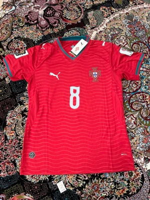 Portugal vm tröja/ Bruno Fernandez 8 - 🇩🇪 OBS! Jag reser till Tyskland 23 Juli – 30 Juli och kan därför inte skicka paket under denna period.  ✅ Plagget är i nyskick med originallapp och förpackning kvar.  📦 Köper du nu reserverar jag varan åt dig och skickar direkt när jag är tillbaka den 30 Juli. Betalning sker nu, frakt sker efter hemkomst.  💬 Hör av dig om du har frågor – svarar så snart jag kan! 🙏