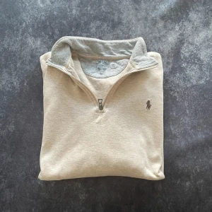 Polo Ralph Lauren beige quarter zip-tröja i bomull för herrar, storlek L/M - Kvalitativt material i 100 % mjuk bomull och en tidlös klassisk modell. Mycket fint skick.  Mått 📏 Armhåla till armhåla: 59 cm Längd från kragen: 65 cm Ärmlängd från axeln: 59 cm  Skickas inom ett dygn Spara på priset och frakten genom att sätta ihop ett paket  Mer information finns på min profil