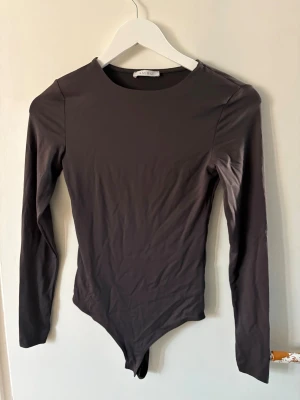 Body - Mörkgrå långärmad body från new yoker storlek S