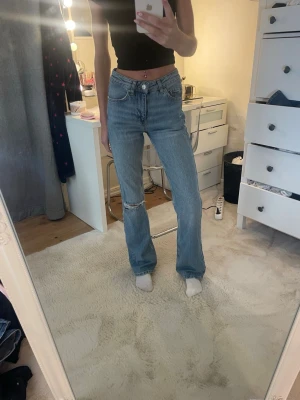 Blå raka jeans från Perfect Pants - Säljer ett par ljusblå raka jeans från Gina tricot med hög midja och slitning vid knät. Klassisk femficksmodell i mjuk denim som ger en avslappnad vibe. Perfekta till crop tops eller hoodies för en chill look.