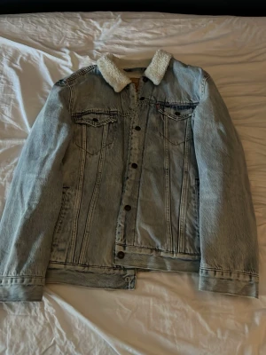 Jeansjacka Levis - Säljer en fin fodrad jacka från Levis, perfekt till höst och vinter. Jackan är i fint skick utan synliga skador. Storlek XL men lite mindre i storleken enligt mig så funkar perfekt om du brukar ha L