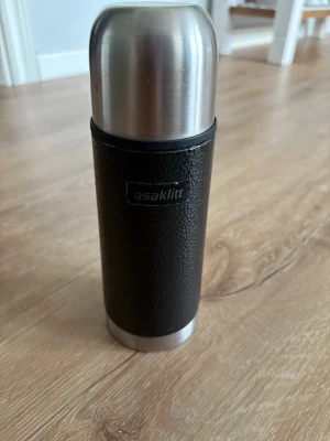 Svart termos från Asaklitt - Praktisk svart termos från Asaklitt med detaljer i rostfritt stål. Perfekt för att hålla drycker varma eller kalla under längre tid. Termosen har en stilren och enkel design med greppvänligt material runt om. Kolla gärna mina andra annonser❗️