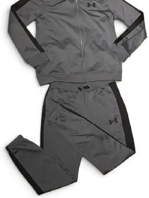 Grå träningsset från Under Armour - Snyggt grått träningsset från Under Armour med svarta detaljer längs ärmar och ben. Setet består av en ziptröja med hög krage och matchande byxor, båda i mjukt och stretchigt funktionsmaterial. Perfekt för träning eller chill.