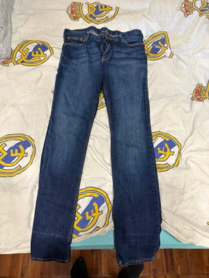 Armani Mörkblå raka jeans - Snygga mörkblå jeans från Armani med raka ben och klassisk femficksdesign. Jeansen har kontrastsömmar och en liten logodetalj på bakfickan. Tillverkade i denim med lätt tvättad look för en avslappnad stil.