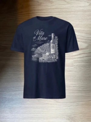 Vita di Mare t-shirt med tryck - Snygg t-shirt med trycket 'Vita di Mare' och motiv av vinflaska och citroner. Finns i både marinblått och vitt med kontrasterande tryck. Klassisk rund hals och korta ärmar. Perfekt för dig som gillar stilrena motiv och italienska vibbar. Riktigt fräsch och är av väldigt hög kvalité. Tveka inte att höra av er vid frågor!