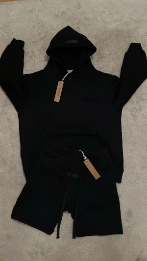 Svart Essentials set  - Riktigt fet Svart Essentials set, helt ny i storlek S. Hoodie plus shorts som är oanvända kommer med original essentiell påsarna. Först till kvarn 