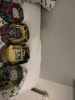 Pokémon burkar med samlarkort - Säljer en stor samling Pokémonkort två burkar samt en gul Pokémonpärm. Perfekt för dig som vill utöka din samling, vet inte så mycket om korten det ända jag vet är att har något eller flera kort som är värt 100-120. Samt några pikachu kort 