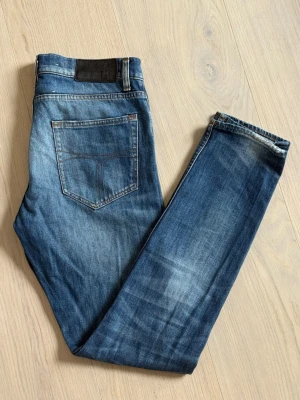 Tiger of Sweden jeans - Snygga blå jeans med klassiska fem fickor och diskreta slitningar på benen. Jeansen har normal midja, bälteshällor och kontrastsömmar. Perfekta för en avslappnad och trendig look. Modellen pistolero, som för övrigt är Tiger of Swedens mest populära jeansmodell. I princip helt nya, endast använda ett fåtal gånger. Vid fler frågor är det bara att höra av sig! W30 L32