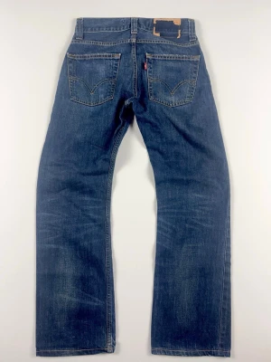 Levi’s 506 Standard Jeans Mörkblå Denim Vintage - Snygga mörkblå Levi’s 506 Standard med snygga fades. Färg: Mörkblå med ljusare partier  Passform: Standard / Straight Skick: Gott skick! B Grade Storlek: Ej angiven. Kolla måtten nedan!  Uppskattningsvis W30, L30 Mått [platt] (±1 cm): A: 35 cm B: 94 cm C: 25 cm D: 20,5 cm Tveka inte att höra av dig vid frågor eller funderingar.  Skickas snabbt!