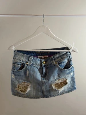 Y2K kjol i jeanstyg med gulddetaljer - Vintage jeanskjol med coola detaljer, köpt på plick passar xs.