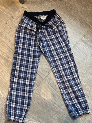 Rutiga pyjamasbyxor Hampton Republic - Mysiga pyjamasbyxor från Hampton Republic i blått och vitt rutigt mönster. Byxorna har resår i midjan och benslut samt snörning i midjan för extra komfort. Perfekta för chillkvällar hemma. Passar inte har knappt använt dom 