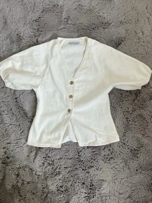 Vit jeanstopp - Söt jeansblus med knappar fram och puffiga armar. I storlek 36 från primark. Använd 1 gång Och är som ny.