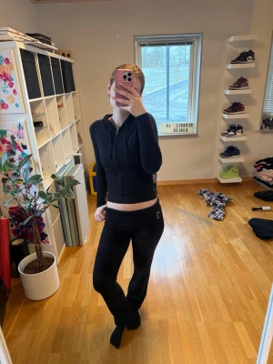 Svart ribbad loungewear-set - Säljer ett svart loungewear-set som var väldigt trendigt för något år sedan. Det är en croppad, ribbad hoodie med dragkedja och långa ärmar samt matchande byxor med liten metall-detalj. Säljer dessa då de inte använts så mycket. Tyvärr så minns jag ej vilken hemsida de köptes på. (OBS, jag har två likadana annonser då jag råkade köpa två likadana set) 