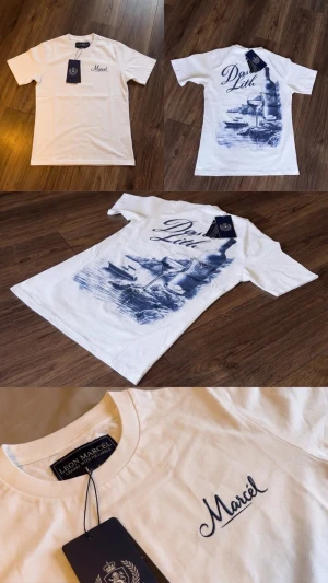Vit t-shirt med blått tryck Marcel - Snygg vit t-shirt från Leon Marcel med blått tryck på bröstet där det står 'Marcel' och en stor, detaljerad blå illustration på ryggen med texten 'Dos Lith'. Klassisk passform och rund hals. Perfekt för dig som gillar unik design och streetwear vibes.