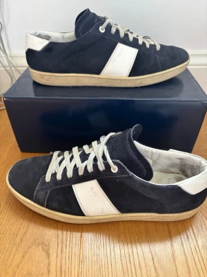 Saint Laurent mörkblå sneakers SL/02 - Hej 👋 skornas skick är 7/10 med tecken på användning. Har endast skorna, men jag garanterar att de är äkta! Storlek 45