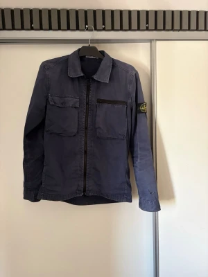 Stone island overshirt - En overshirt ifrån stone island i bra skick! Säljes för den bara hänger i garderoben. Hål i armen annars inga defekt. Storlek M                   Pris kan diskuteras