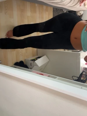 Svarta utsvängda leggings - Säljer ett par svarta leggings med utsvängda ben. De har hög midja och sitter tight över höfterna och låren för en snygg siluett. Perfekta för dig som gillar en trendig och bekväm stil. Materialet ser stretchigt och mjukt ut.