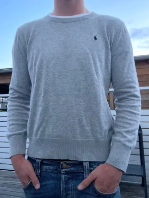 Polo Ralph lauren stickad tröja, strl S - Säljer en fin stickad tröja från Polo Ralph Lauren i grå färg. Mycket fint skick, inga hål eller fläckar. Modellen på bilden är 178 cm lång och väger ca 70kg.                                                                                  Storlek: XL junior, men sitter som en S herr.              Självklart äkta. Skickas inom 24 timmar!