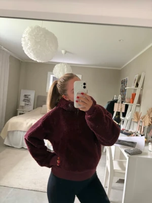 Vinröd teddyhoodie från Lululemon - Mysig vinröd teddyhoodie från Lululemon med huva och dragkedja. Tillverkad i mjukt, fluffigt material som håller dig varm. Perfekt för chill dagar eller när du vill ha något extra bekvämt. Oversized fit och ribbade muddar.