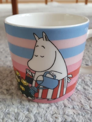 Muminmugg Rosegarden Mumin  - Begagnad mugg. Det finns tecken på användning, som blyertsstreck på ngr ställen (se bilder). Hel, inga nagg. Säljer fler Muminmuggar så kika gärna på mina övriga annonser också. Packar mycket noggrant. 