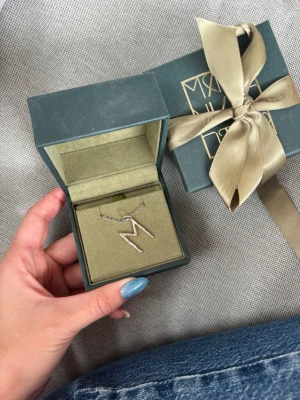 Maria Nilsdotter Wonky Letter M - Säljer mitt fina Wonky Letter Necklace i ett M, ifrån Maria Nilsdotter. Fint skick. Silver. Kedjans längd är 40cm 🤍 Båda boxarna medföljer.