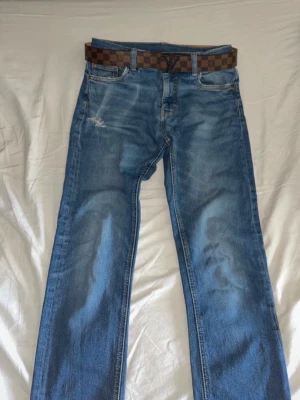 Blå raka jeans från Kappahl - Säljer ett par klassiska blå jeans från Kappahl i rak modell. Jeansen har slitningar vid fickan och snyggt tvättad look. De har fem fickor och normal midja. Perfekta till en avslappnad stil och passar till det mesta.