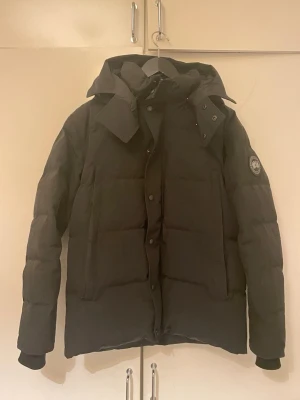 Svart Canada goose Wyndham jacka - Jag säljer nu en iskall Canada Goose jacka i modellen wyndham i en svart färg och svart badge🕴️Jackan är i toppen skick inga fel! Den är i storlek S och är riktig varm och skön som passar bra inför sveriges otänkbara väder. En bärbar påse för jackan hönger också med vid köp! Vid funderingar och intresse äre bara att höra av sog 🫡🙏🥂