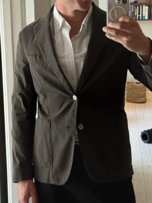 Oscar Jacobson Blazer - En fin mörkgrön blazer från Oscar Jacobson i modellen: Ferry Patch Blazer. Storleken är 48 och måtten är: längd 79 cm, axelbredd: 44, armlängd: 65, midja: 45. Kavajen är väl omhändertagen och i bra skick.