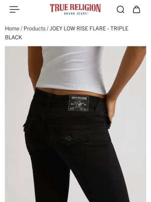 True Religion svarta low rise flare jeans - Andvänt 1 gång pågrund av att dem var för storaSnygga svarta low rise flare jeans från True Religion. Jeansen har låg midja, utsvängda ben och klassiska bakfickor med lock och knapp. Tillverkade i stretchigt denim för en bekväm passform och cool look.