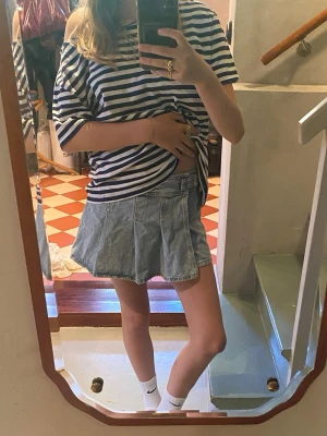 Ljusblå jeanskort från Zara - Säljer en kort ljusblå jeanskjol med hög midja, dekorativa knappar och dragkedja framtill. Kjolen har markerade sömmar som ger en cool look. Perfekt för dig som gillar denim och vill ha en trendig stil.✨💕