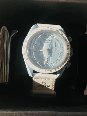 Omega x Swatch MoonSwatch Mission To Uranus - Säljer en Omega x Swatch MoonSwatch Mission to Uranus. Klockan har en ljusblå boett och matchande urtavla med vita detaljer. Armbandet är vitt med Omega-logga. Tillverkad i biokeramik och har en sportig, modern look. Perfekt för dig som gillar unika accessoarer.