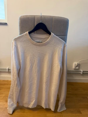Beige stickad tröja These Glory Days - Snygg beige stickad tröja från These Glory Days i storlek M. Tröjan har rund halsringning och är tillverkad i mjuk merinoull. Perfekt för lager-på-lager och enkel att matcha med olika outfits.