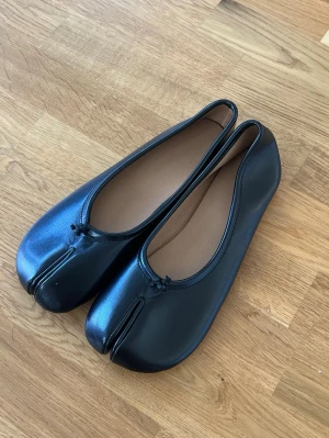 Svarta tabi ballerinaskor i skinn - Säljer ett par svarta tabi-ballerinor. Snygga, trendiga och sköna. Storlek 41 men passar 40. (Aldrig använda) 🖤🖤