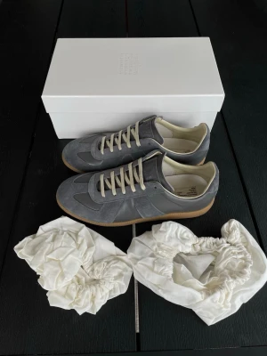 Margiela GATS | Grå - Säljer ett par stilrena Maison Margiela gats i färgen grå. | Storlek: 44 | Skick: 9.5/10, endast använda fåtal gånger | Kommer komplett med box och dustbags | Skickas samma dag som köp, och paketet packas noggrant för att säkerställa att varan kommer fram i bästa skick. | Pris: 3299kr, går att diskuteras vid snabb affär. | PM vid frågor om pris, eller andra frågor om varan. // William