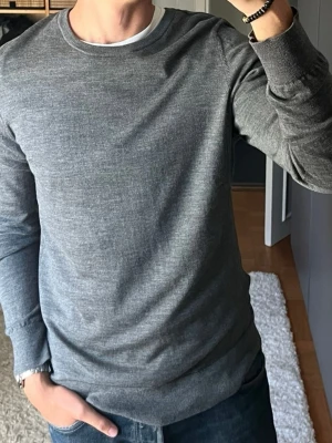 Samsøe Samsøe merinotröja i grå - stl XL - Samsøe Samsøe merinotröja i gråmelerad, storlek XL i 100% merinoull. Personen på bilden är 189cm, väger 78kg.  Använd men i mycket fint skick, inga hål eller fläckar.  Rök- och djurfritt hem. Skriv gärna om du vill ha fler bilder eller undrar något!