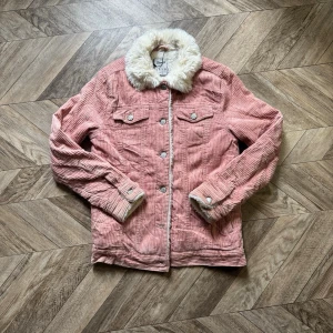 Pink Corduroy Jacket with Faux Fur Collar - This is a light pink corduroy jacket featuring a plush, white faux fur collar and lining. The jacket has a button-up front with two chest pockets and buttoned cuffs. The brand is Denim Co., and the size is UK 4, EUR 32, USA 0, IT 36. Made in China.