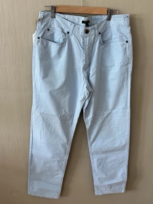 Burberry London Ljusblå raka jeans - Snygga ljusblå jeans från Burberry London med rak passform och klassisk femficksdesign. Jeansen har bälteshällor, knapp- och dragkedjegylf samt detaljer i metall. Perfekta för en avslappnad och trendig look.0090