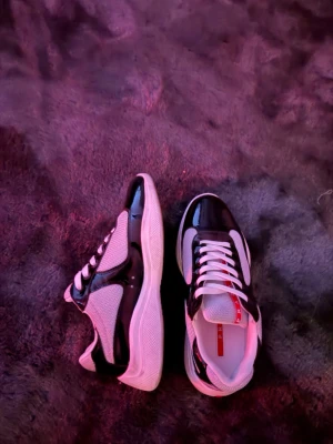 Svarta och vita sneakers med meshdetaljer - Snygga sneakers i svart och vitt med vita snören och sula. Ovandelen har både blanka partier och meshdetaljer för en sportig look. Perfekta för dig som vill ha en modern och stilren sneaker.Har låda men den är dåligt skick . Skicka gärna bud eller om ni har frågor 