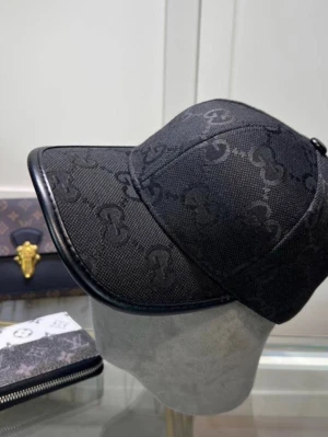 Svart GG keps - Snygg svart keps med diskret GG-monogram över hela tyget och svarta detaljer längs skärmen. Kepsen har en klassisk form och är tillverkad i ett tåligt canvasmaterial med läderliknande kant. Perfekt för dig som gillar stilrena accessoarer.
