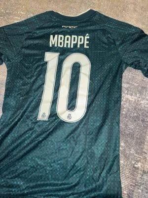 Real Madrid Mbappé matchtröja grön - Säljer en grön Real Madrid matchtröja med Mbappé och nummer 10 på ryggen. Endast testat . Slim fit