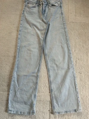 Ljusblå raka jeans - Säljer ett par ljusblå jeans med rak passform och klassisk femficksdesign. Jeansen har  låg midja och är tillverkade i denim. 