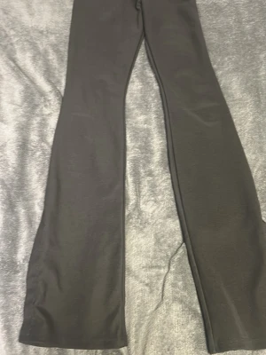 Svarta utsvängda leggings - Säljer ett par svarta leggings med utsvängda ben. De har en enkel och stilren design utan synliga detaljer eller mönster. Perfekta för dig som gillar en clean och bekväm look. Materialet känns mjukt och stretchigt. De är helt nya✨