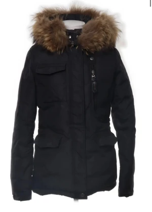 Svart parkajacka med stor pälsluva - Ser ut som en helt ny jacka. Snygg svart parkajacka med fluffig brun päls runt luvan. Jackan har flera fickor framtill, dragkedja och knappstängning. Perfekt för kalla dagar med sin långa passform och varma material. Luvan är stor och ger extra skydd mot vind och kyla. Stor päls dm för bättre bilder