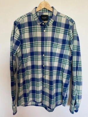 VAILENT PURE Rutig Skjorta L | Blå/Grön | Cotton  - Snygg VAILENT PURE rutig skjorta i bomull 💙 Perfekt för hösten.    •  Märke: VAILENT PURE   •  Storlek: L   •  Material: 100% bomull. Mjuk och skön  •  Modell: Button-down krage, knappstängning fram, 1 bröstficka, lång ärm  •  Skick: Som nytt. Tvättad, ingen noppning, inga fläckar, inga defekter   Klassisk passform som går att bära både knappad eller öppen över en t-shirt.   Obs! T-shirt på bilden ingår inte i priset.