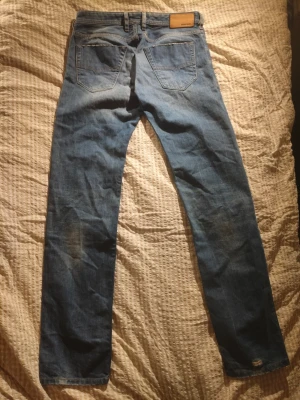 Blå slim-tapered jeans från Diesel - Säljer ett par blå jeans från Diesel, modell Koolter. De har en slim-tapered passform och klassisk femficksdesign. Jeansen har en snygg tvätt och raka ben, perfekta för en avslappnad men ändå stilren look.