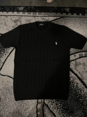 Polo Ralph T-shirt  - Helt ny, Svart ribbad t-shirt från Polo Ralph Lauren i storleken S, passar perfekt för nån i längden 170-175