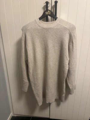 Stickad klänning - Beige stickad klänning från Pull & Bear, strl S. Går lite längre ner än mitten av låren ungefär, använd 2 gånger