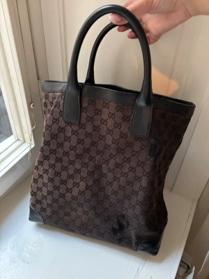 Gucci väska vintage - Vintage gucci väska. Tyvärr har den defekter där textilmaterialet gått upp. Skinnhandtag och detaljer. 