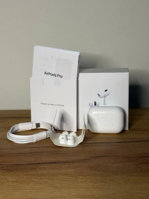 Apple AirPods Pro trådlösa hörlurar - Säljer ett par Apple AirPods Pro med laddningsetui, extra silikonpluggar och laddkabel. Hörlurarna är vita, har en stilren och kompakt design och levereras i originalförpackning. Perfekta för musik, samtal och brusreducering.
